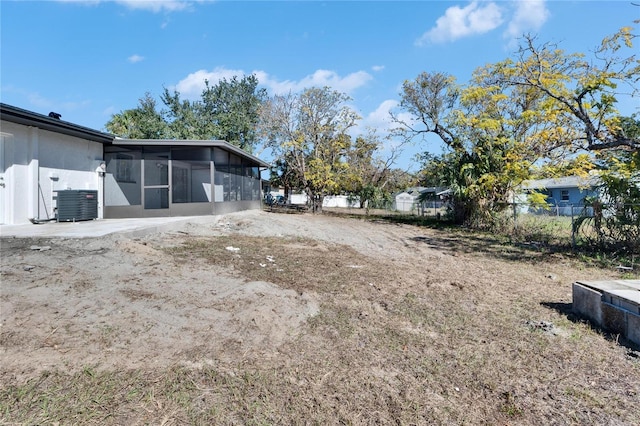 view of yard featuring central AC unit and a sunroom