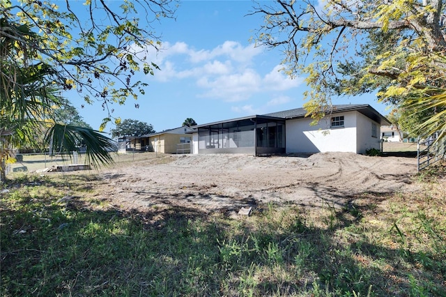 rear view of property featuring a sunroom