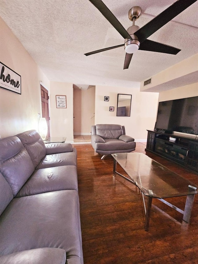 living room with a textured ceiling and dark wood-type flooring