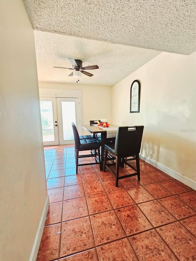 tiled dining area featuring french doors, a textured ceiling, and ceiling fan