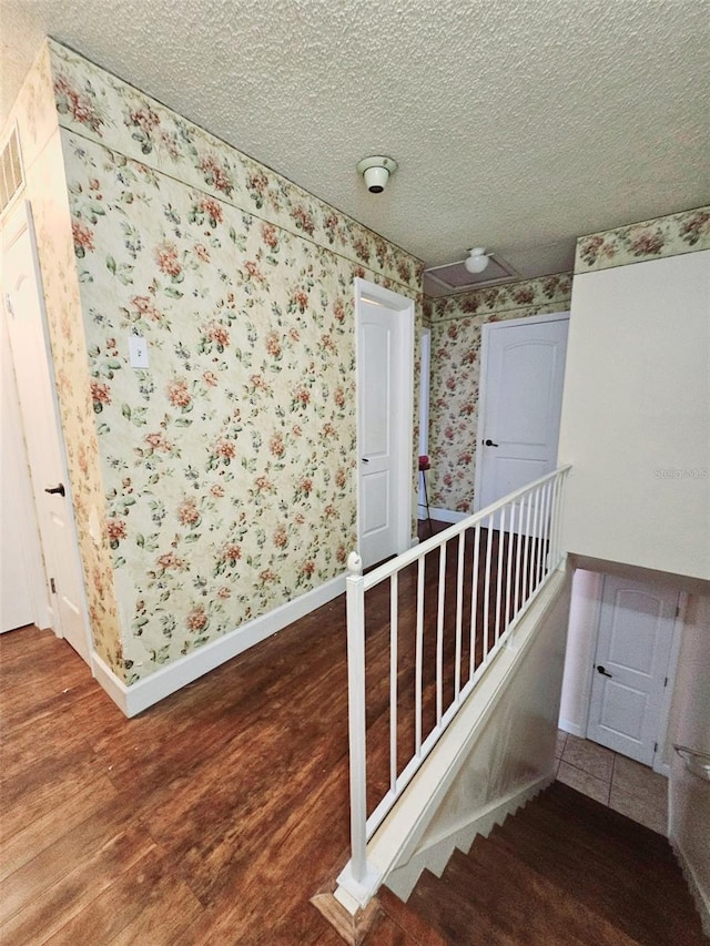 hall featuring a textured ceiling and hardwood / wood-style flooring