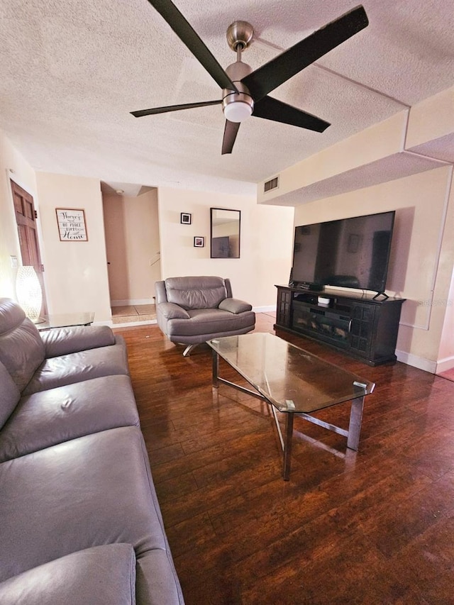 living room with a textured ceiling and dark wood-type flooring