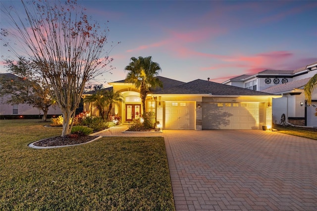 view of front of house with a garage and a lawn