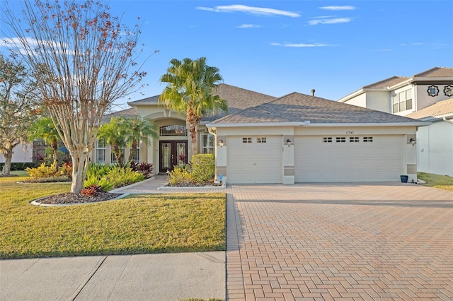 view of front facade with a front lawn, french doors, and a garage