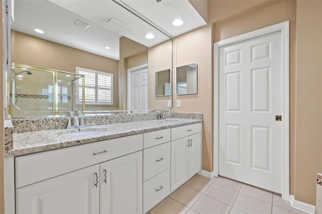 bathroom with vanity, a shower with door, and tile patterned flooring