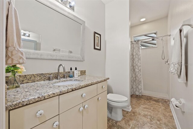 bathroom with vanity, toilet, and curtained shower