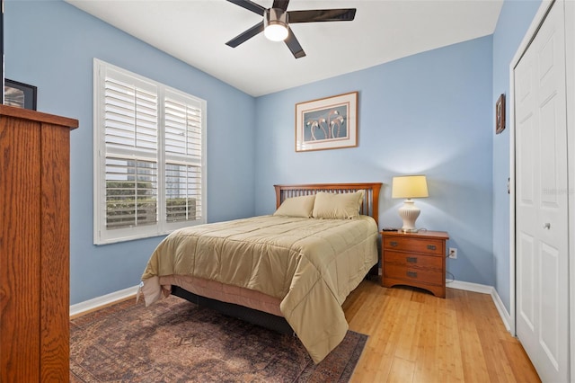 bedroom featuring ceiling fan, a closet, and light wood-type flooring