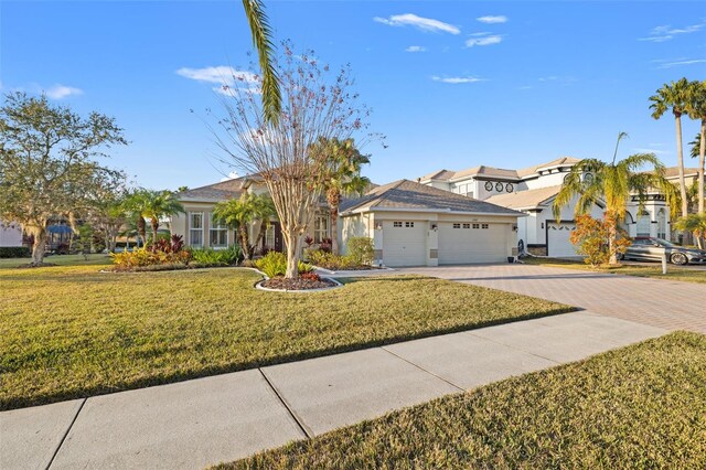 ranch-style home with a garage and a front lawn