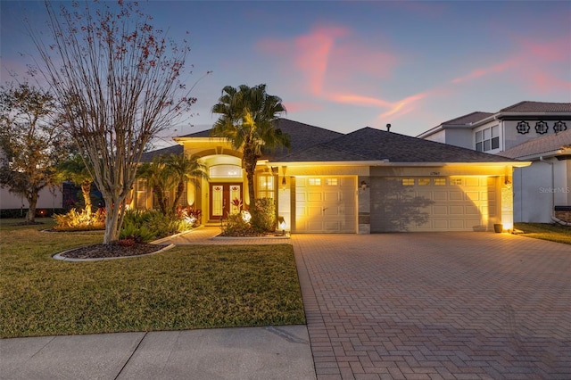 view of front of property with a garage and a lawn