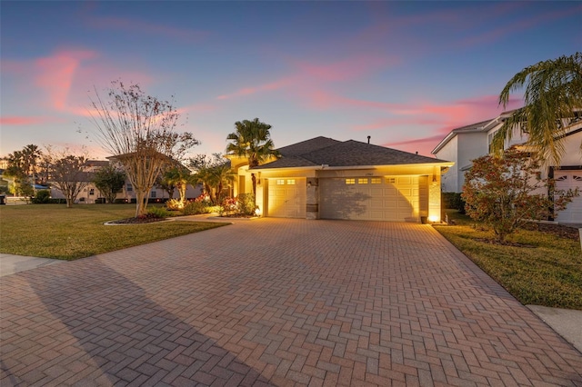 view of front facade with a garage and a yard