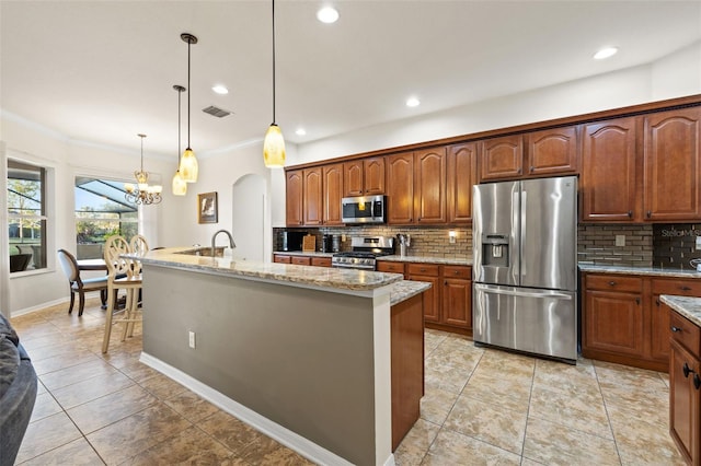 kitchen with a kitchen island with sink, hanging light fixtures, backsplash, stainless steel appliances, and a chandelier