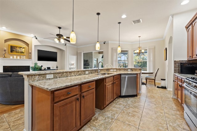 kitchen with pendant lighting, ceiling fan with notable chandelier, a kitchen island with sink, and stainless steel appliances