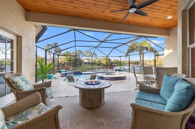 view of patio featuring an in ground hot tub, an outdoor hangout area, and glass enclosure