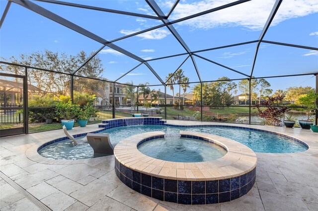 view of swimming pool featuring an in ground hot tub, pool water feature, glass enclosure, and a patio