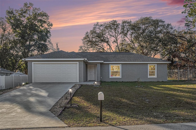 ranch-style house featuring a yard and a garage