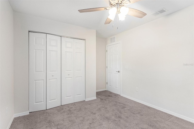 unfurnished bedroom with light carpet, a closet, and ceiling fan