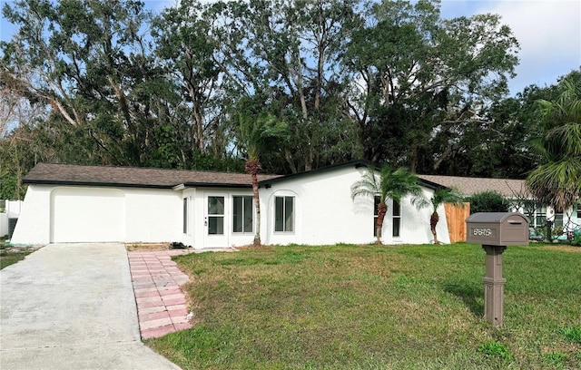 ranch-style home with a garage and a front lawn