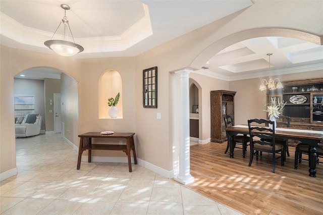 corridor with coffered ceiling, a notable chandelier, wood-type flooring, a tray ceiling, and ornamental molding