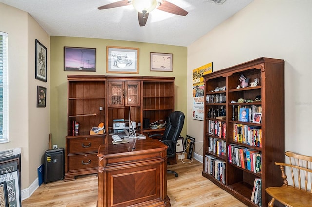 office with ceiling fan, light hardwood / wood-style floors, and a textured ceiling