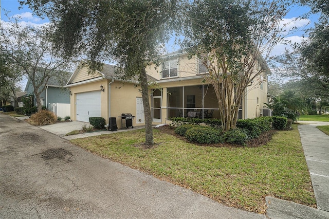 view of front of home with a front yard, a garage, and a sunroom