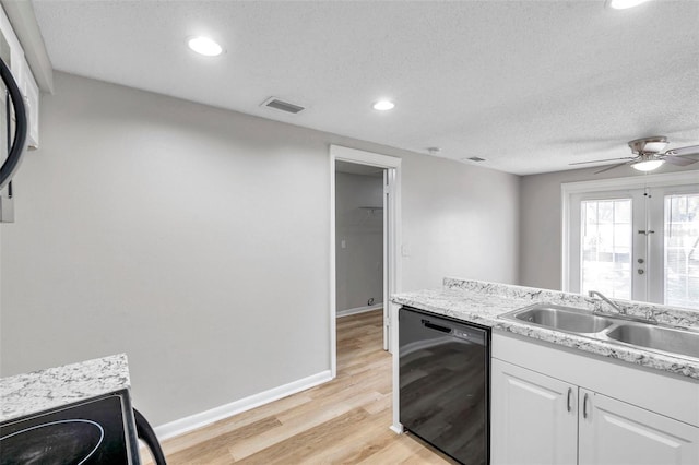 kitchen featuring sink, white cabinetry, a textured ceiling, black dishwasher, and light hardwood / wood-style flooring