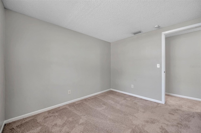 carpeted spare room with a textured ceiling