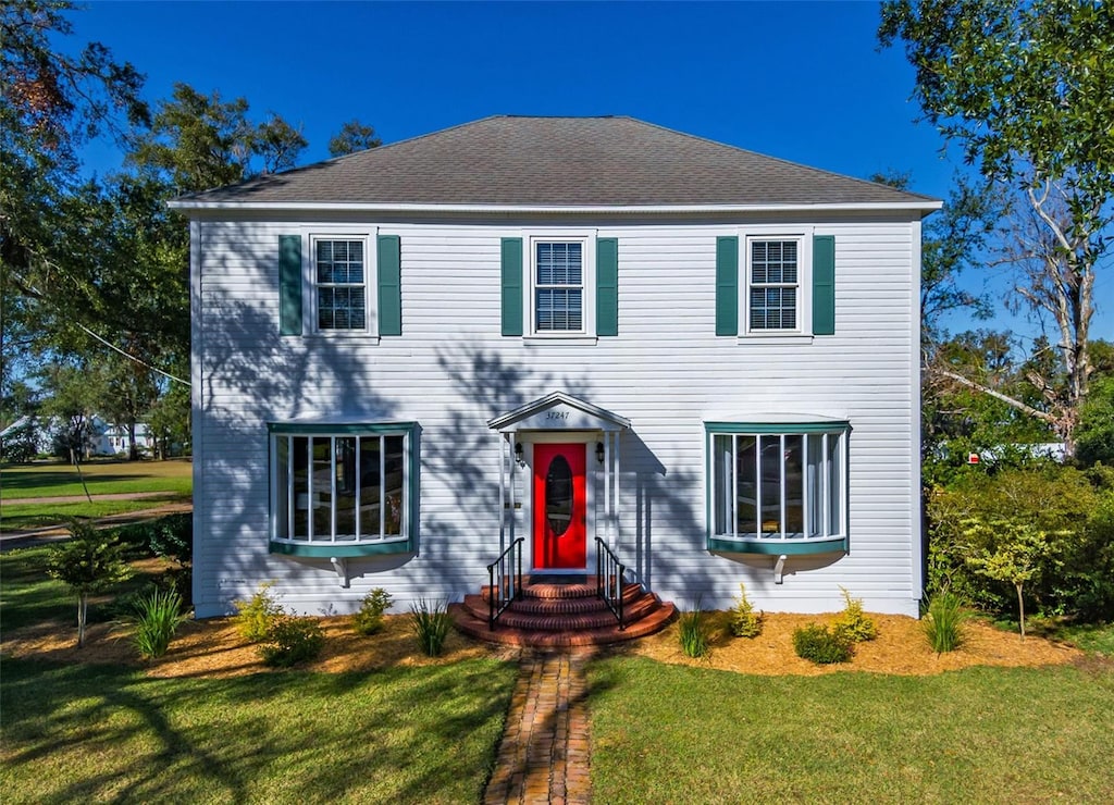 colonial house featuring a front yard