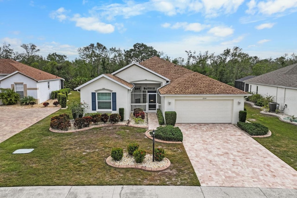 single story home featuring a garage, central air condition unit, and a front yard