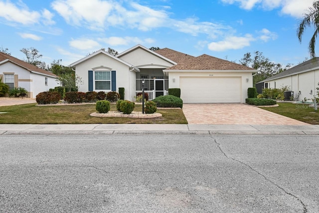 single story home featuring central air condition unit, a front lawn, and a garage