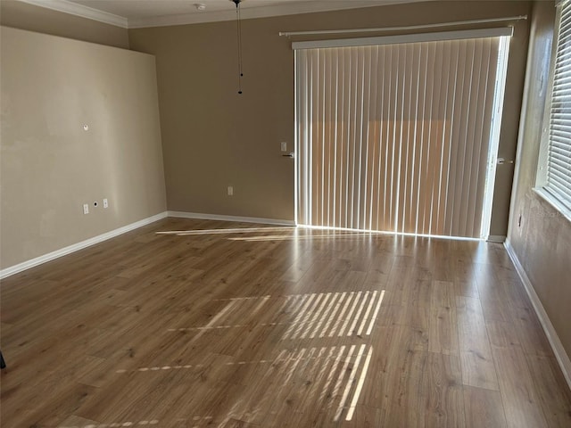 empty room with ornamental molding and hardwood / wood-style flooring