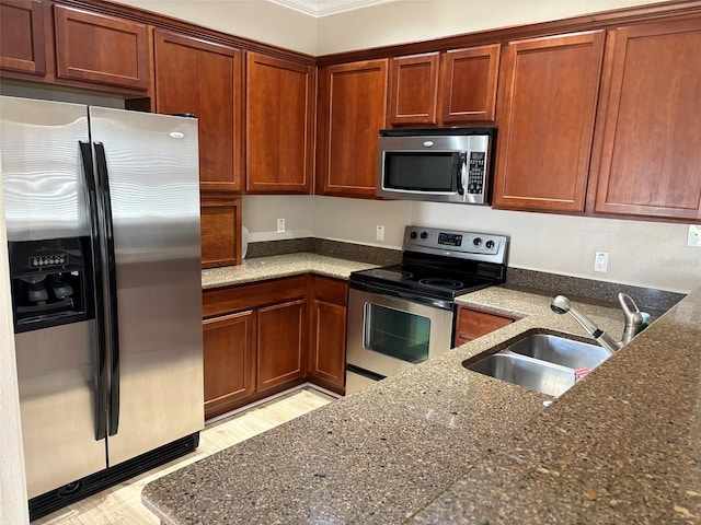 kitchen with sink, appliances with stainless steel finishes, and dark stone counters