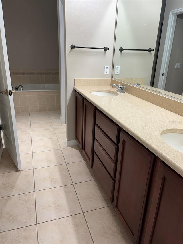 bathroom with tiled bath, tile patterned floors, and vanity