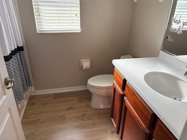 bathroom with toilet, walk in shower, hardwood / wood-style floors, and vanity