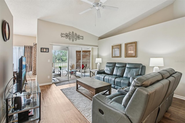 living room featuring ceiling fan, hardwood / wood-style flooring, and vaulted ceiling