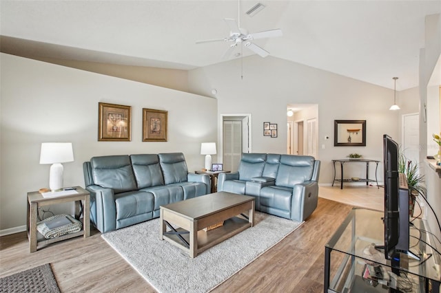 living room featuring ceiling fan, lofted ceiling, and light hardwood / wood-style flooring