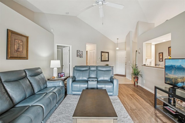 living room with ceiling fan, high vaulted ceiling, and light hardwood / wood-style flooring