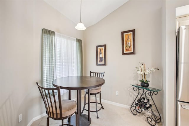 dining space with lofted ceiling and light tile patterned flooring