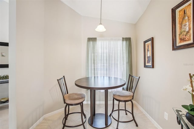 dining space with light tile patterned flooring and lofted ceiling