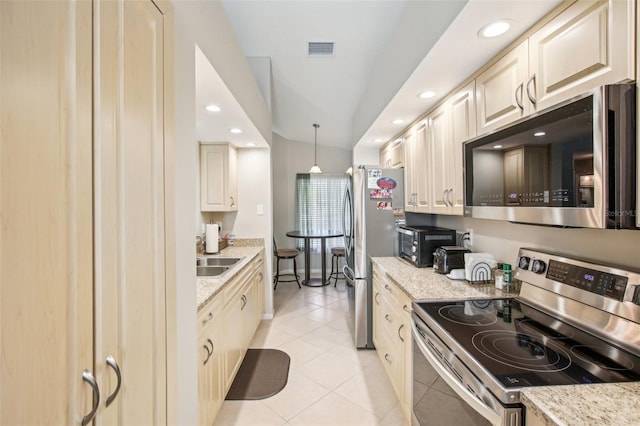 kitchen featuring pendant lighting, appliances with stainless steel finishes, lofted ceiling, light stone counters, and light tile patterned floors