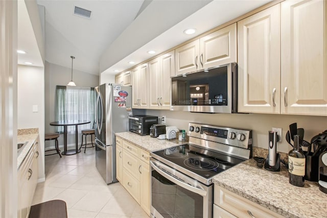 kitchen featuring stainless steel appliances, light tile patterned flooring, light stone countertops, vaulted ceiling, and pendant lighting