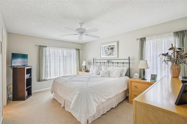 carpeted bedroom featuring ceiling fan and a textured ceiling