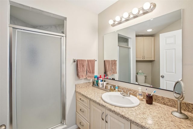 bathroom featuring walk in shower, vanity, and toilet