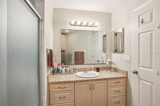 bathroom featuring walk in shower and vanity