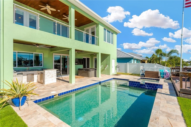 back of property with an outdoor bar, a patio, a hot tub, and ceiling fan