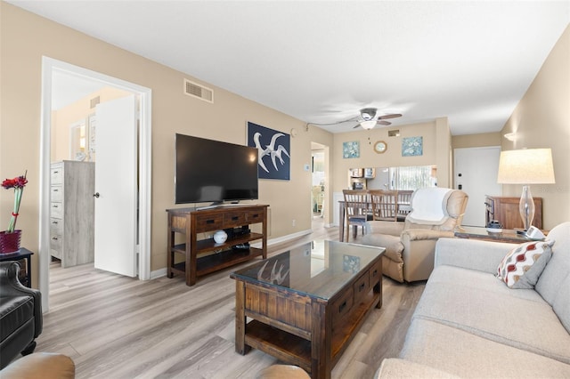 living room featuring ceiling fan and light hardwood / wood-style floors