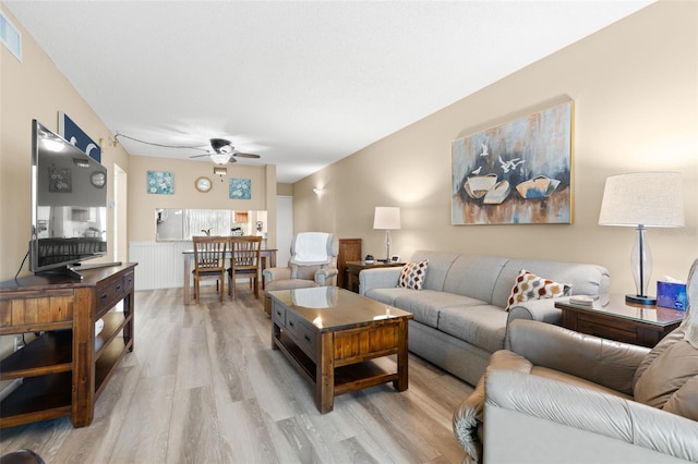 living room with ceiling fan and light hardwood / wood-style flooring