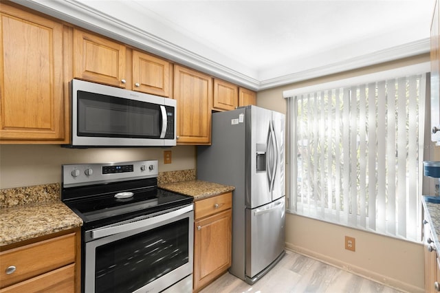 kitchen with light hardwood / wood-style floors, light stone countertops, stainless steel appliances, and ornamental molding