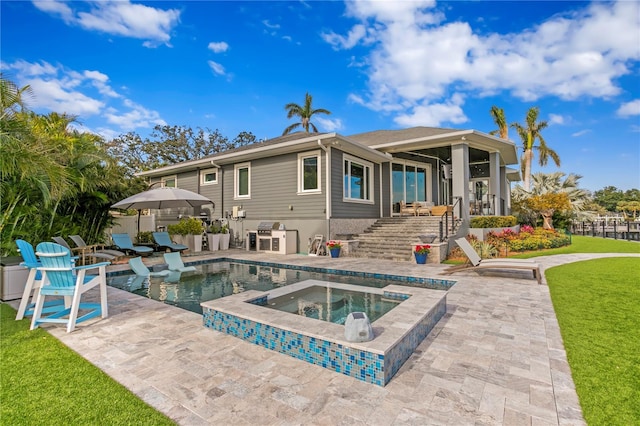 back of house with a yard, a patio area, and a swimming pool with hot tub