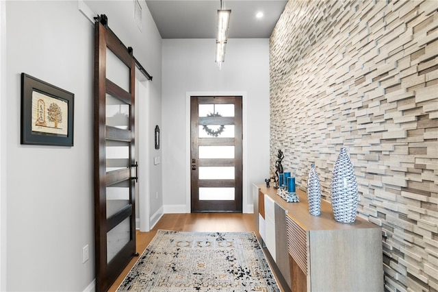 foyer featuring a barn door and light hardwood / wood-style floors