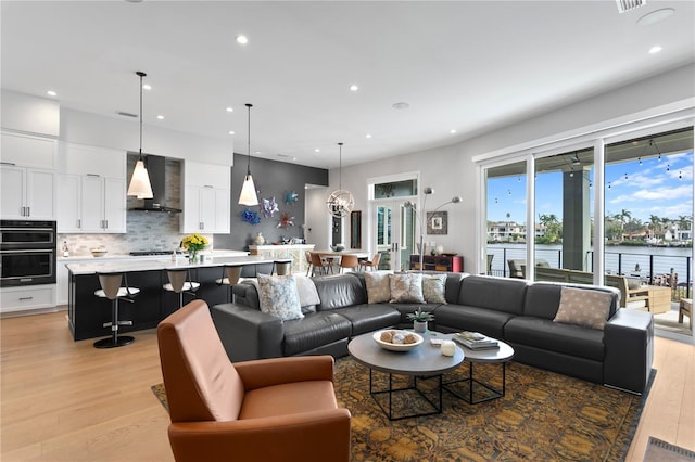 living room with light hardwood / wood-style floors and a water view